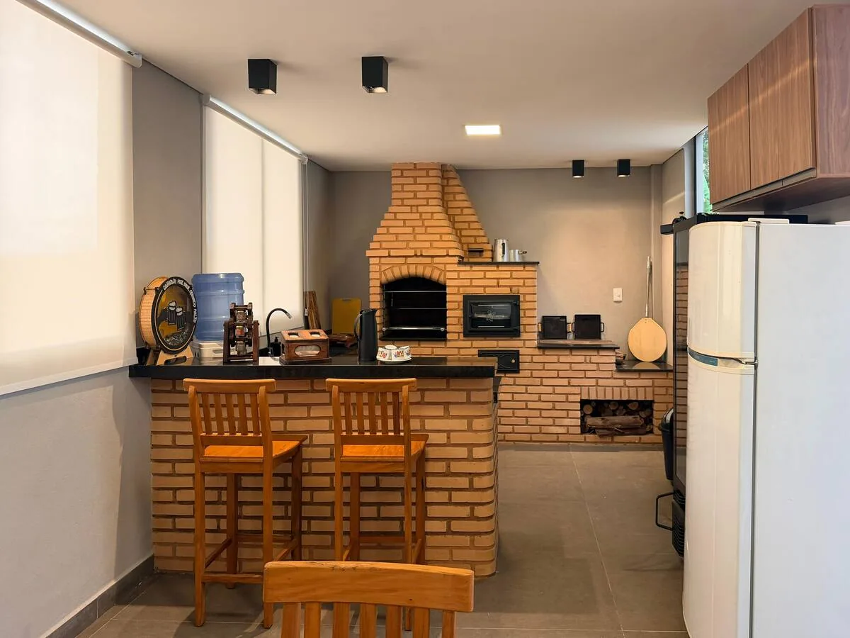 Área gourmet com churrasqueira e mesa ampla